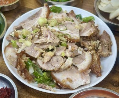 흰 접시에 썬 족발을 담고 송송 썬 파와 깨를 올린 모습